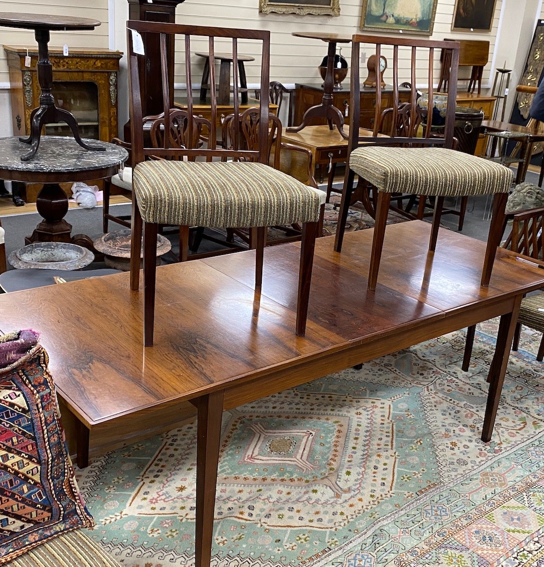 A mid century rosewood extending dining table, length 214cm extended, width 84cm, height 72cm six chairs and wall hanging side cabinet